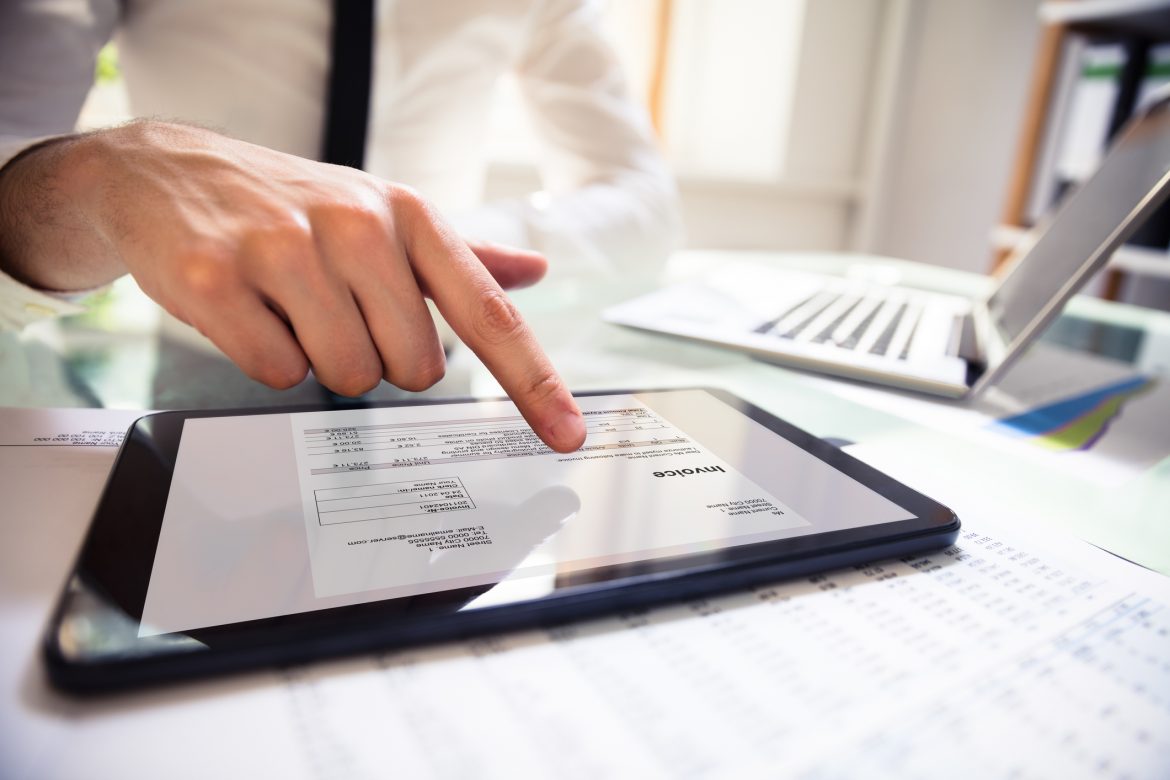 Businessperson Analyzing Invoice On Digital Tablet invoice online